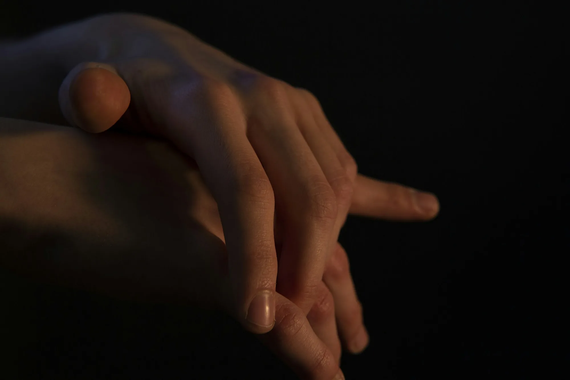 Two hands close together in warm intimate light