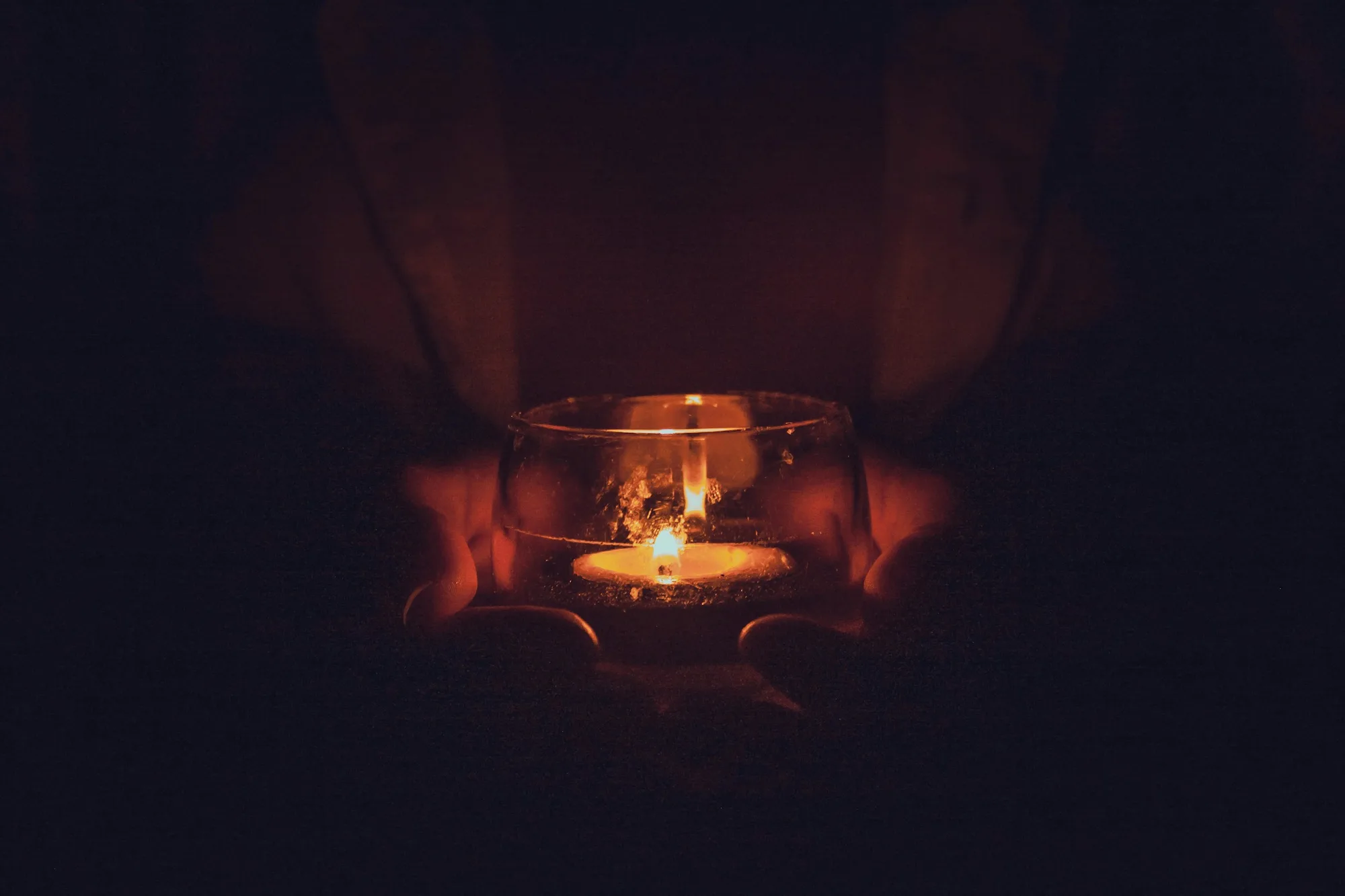 Hand in candlelight, warm intimate private atmosphere